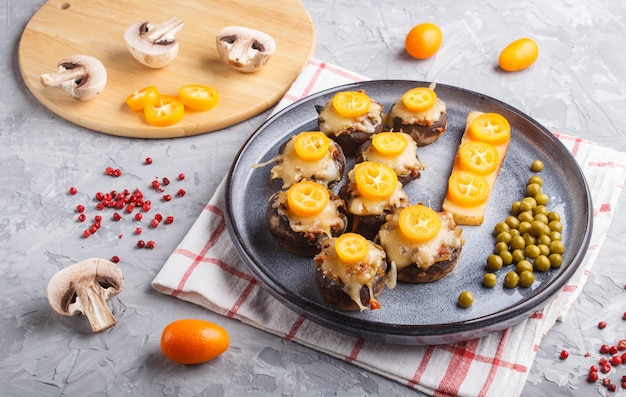 Champignon frito recheado com queijo, kumquats e ervilhas verdes em cinza