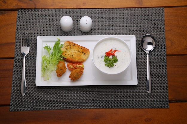 Champignoncremesuppe in einer weißen Schüssel mit geröstetem Brot und frischem grünem Gemüsesalat