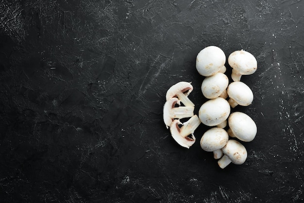 Champignons Pilze auf einem schwarzen Holztisch Draufsicht Freier Platz für Text