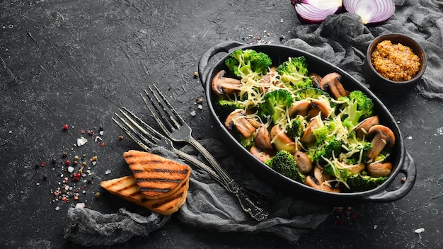 Champiñones al horno y brócoli con queso en una sartén negra Vista superior Espacio libre para su texto Estilo rústico