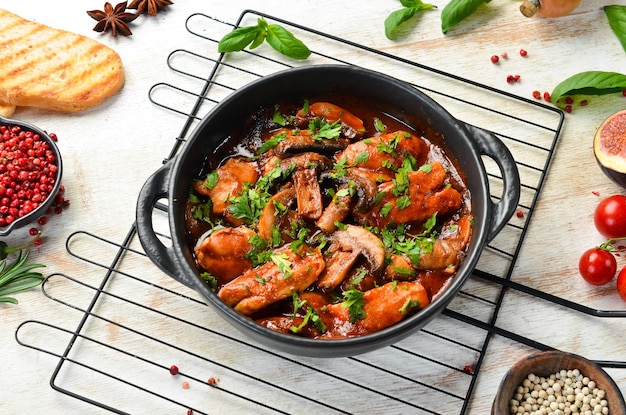 Champiñones al horno con filete de pollo en salsa de tomate En un plato de piedra negra Vista superior