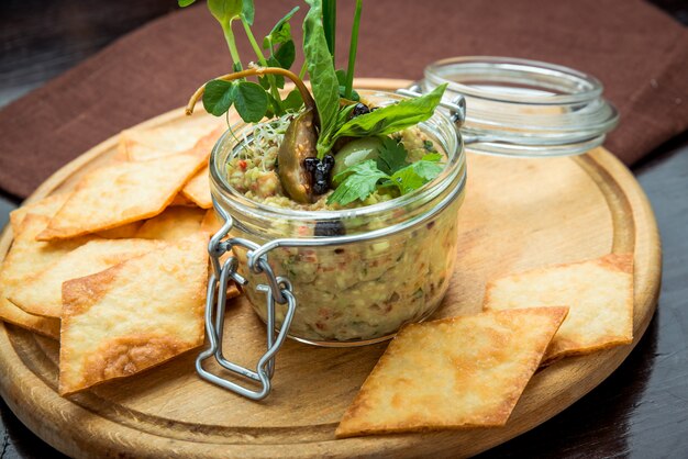 Champiñones caseros y pasta de frijoles. Paté en frasco de vidrio sobre mesa de madera rústica.