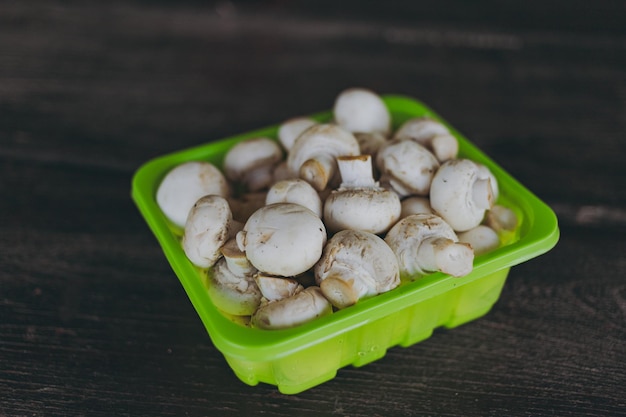 Champiñones de champiñones en un tazón verde sobre la mesa