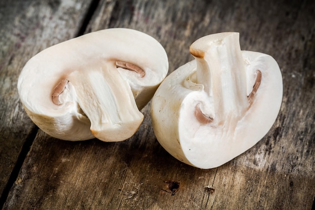 Champiñones crudos en una mesa de madera rústica de cerca