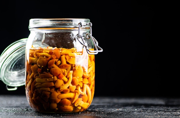 Champiñones en escabeche fragantes en un frasco de vidrio