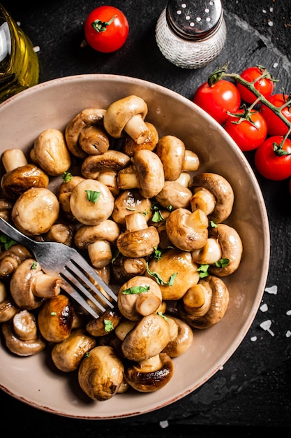 Champiñones fritos en un bol con tomates cherry