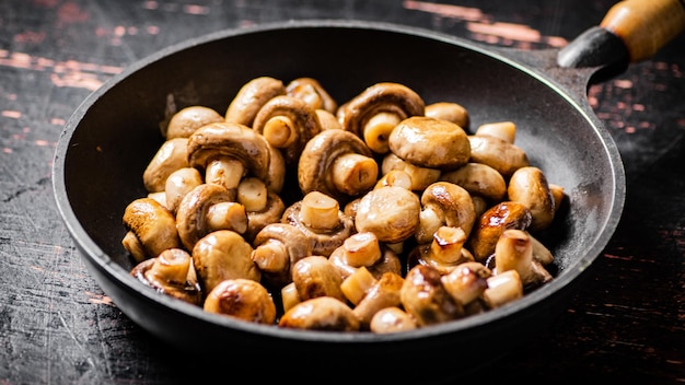 Champiñones pequeños fritos en una sartén