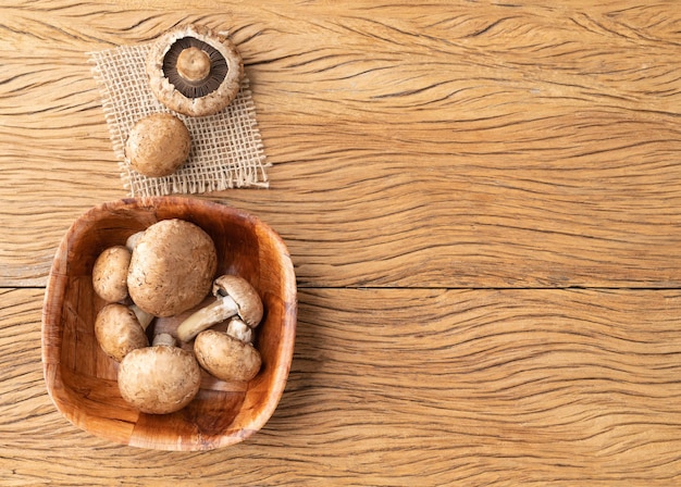 Champiñones portobello en un bol sobre una mesa de madera con espacio para copiar