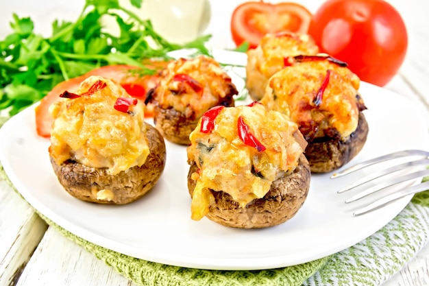 Champiñones rellenos de carne en plato blanco sobre tablero ligero