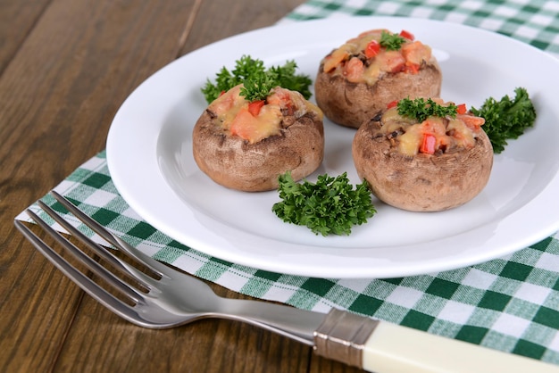 Champiñones rellenos en un plato en el primer plano de la mesa