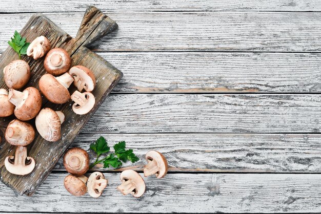 Champiñones sobre un fondo blanco de madera Champiñones Vista superior Espacio de copia libre