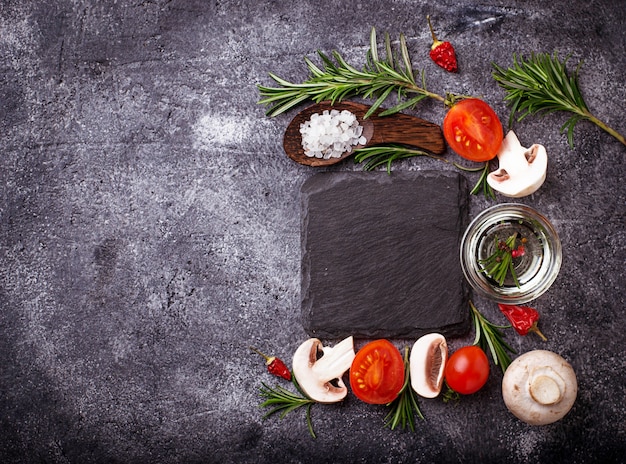 Champiñones, tomates, romero, sal y aceite. Fondo de la comida Vista superior. Espacio para texto