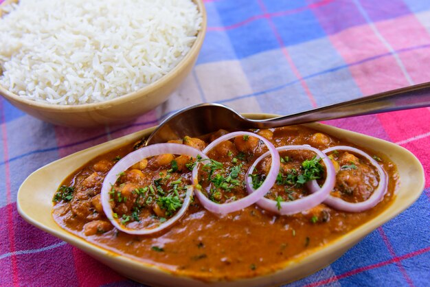 Chana masala com rodelas de cebola e arroz simples a vapor.