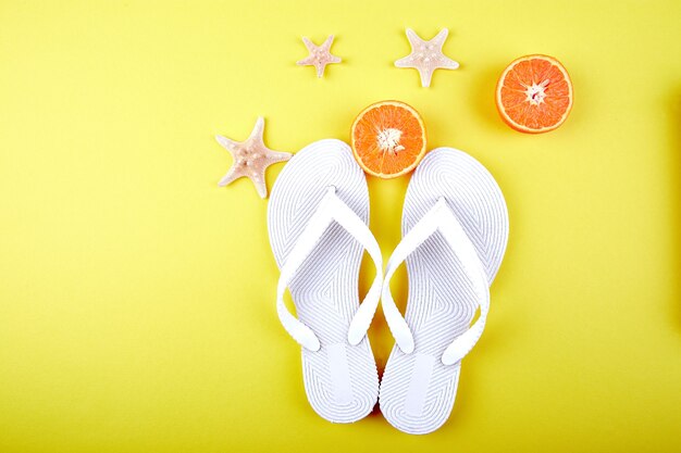 Chanclas blancas, fruta naranja, estrella de mar