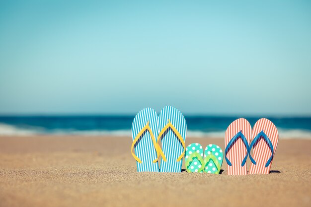 Chanclas de playa en la arena Concepto de vacaciones de verano