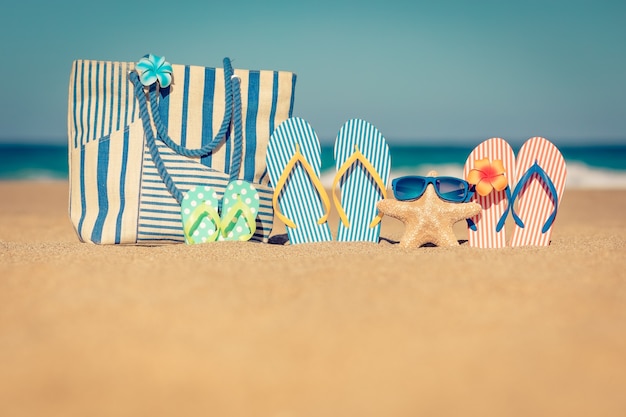 Chanclas de playa en la arena Concepto de vacaciones de verano