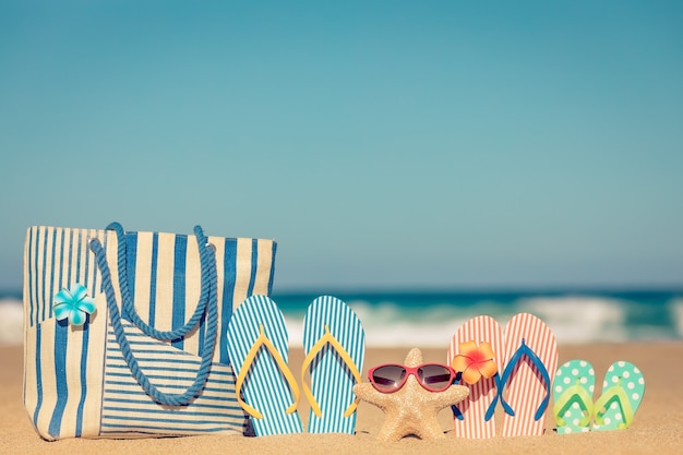 Foto chanclas de playa en la arena concepto de vacaciones de verano