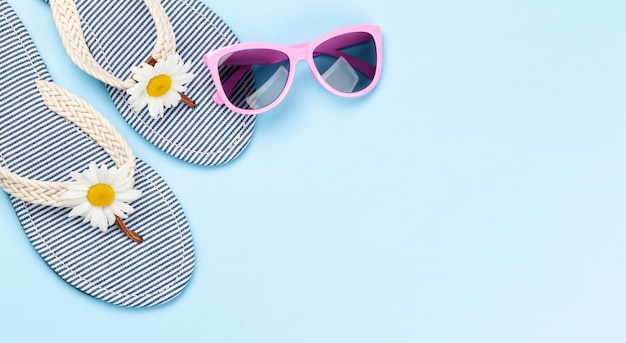 Chanclas de playa con flores y gafas de sol