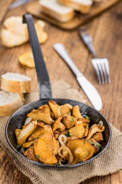 Chanterelles fritos em foco seletivo de fundo de madeira