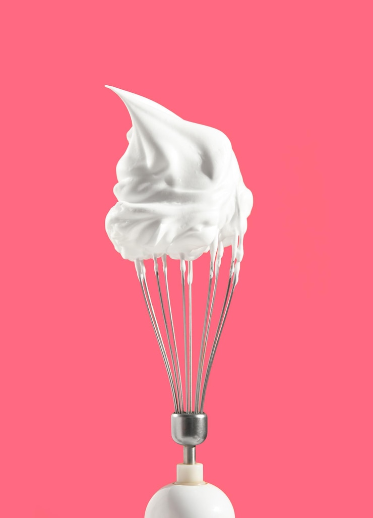 Foto chantilly no topo da batedeira de cozinha. processo de fazer obra-prima de confeitaria. humor doce e estética de cozinhar.