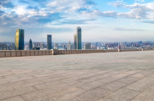 Foto chão de tijolos vazio com fundo do horizonte da cidade