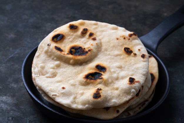 Foto chapati tradicional indio de pan plano. en sartén de hierro fundido concepto de cocina casera fácil. de cerca.