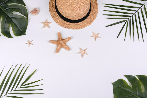 chapéu com conchas e estrelas do mar em um fundo branco. Fundo de verão