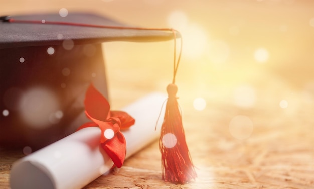 Chapéu de formatura e diploma em fundo de madeira