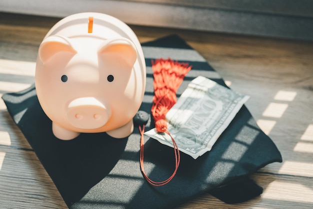 Chapéu de formatura preto e conceito de cofrinho investimento em educação graduação economiza dinheiro para educação