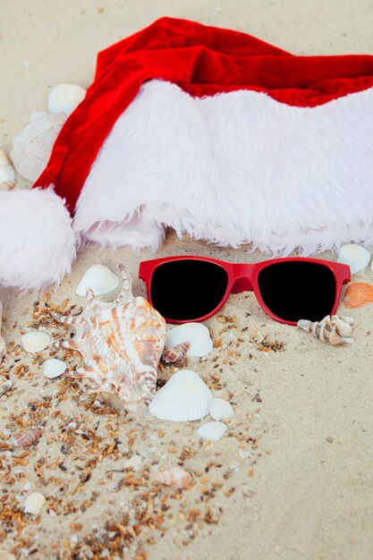 Chapéu de natal e óculos de sol vermelhos na praia