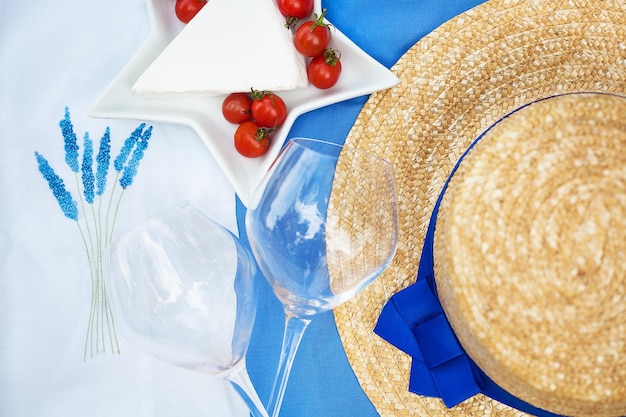 Chapéu de óculos de tomate com queijo na toalha de mesa azul