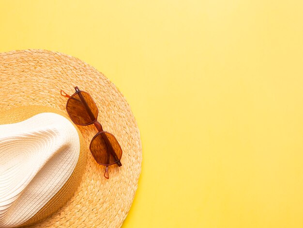 Chapéu de palha mulher com óculos de sol vista superior fundo amarelo brilhante plana leigos