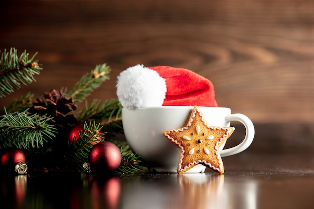 Chapéu de papai noel e copo com biscoito de gengibre