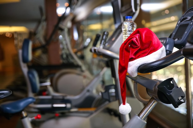 Chapéu de Papai Noel em máquina de fitness moderna na academia