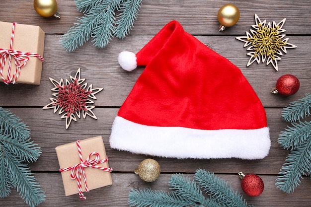 Foto chapéu de papai noel vermelho e presentes em fundo cinza. decoração de natal.