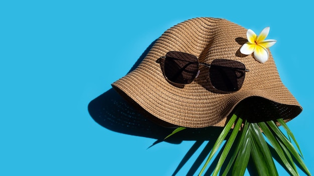 Chapéu de verão com óculos de sol em fundo azul Aproveite o conceito de férias Copie o espaço