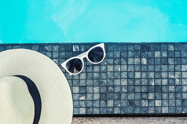 Chapéu e óculos de sol na piscina de luxo tropical beach resort