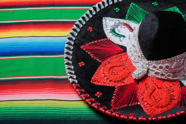Chapéu mariachi com as cores da bandeira mexicana em um poncho colorido