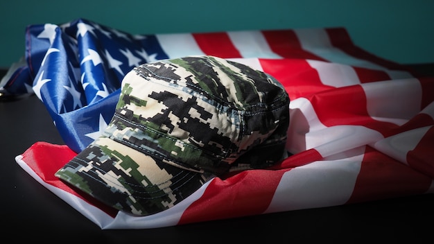 Chapéu militar ou bolsa com a bandeira americana. Chapéu de soldado ou capacete com a bandeira nacional americana em fundo preto. Representa o conceito militar por objeto de camuflagem e a bandeira da nação dos EUA.