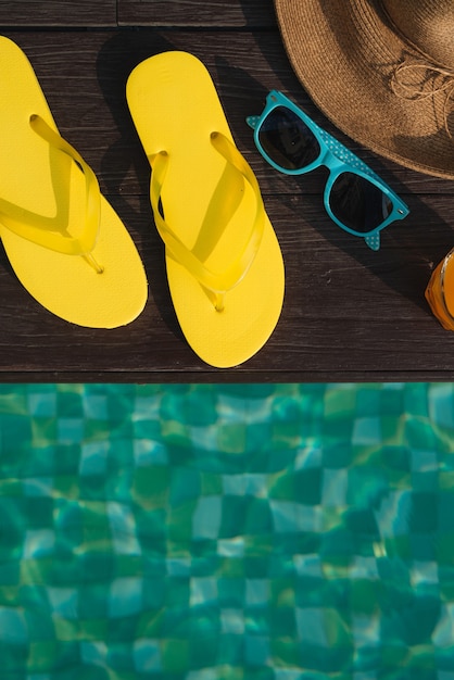 Chapéu, óculos de sol e chinelos na piscina