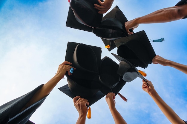 Chapéus de graduação jogados no ar graduados de sucesso da universidadeConcept educação parabéns graduados na universidade