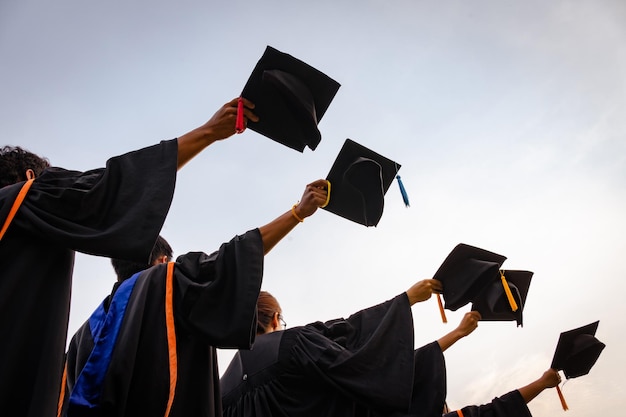 Chapéus de graduação jogados no ar graduados de sucesso da universidadeConcept educação parabéns graduados na universidade