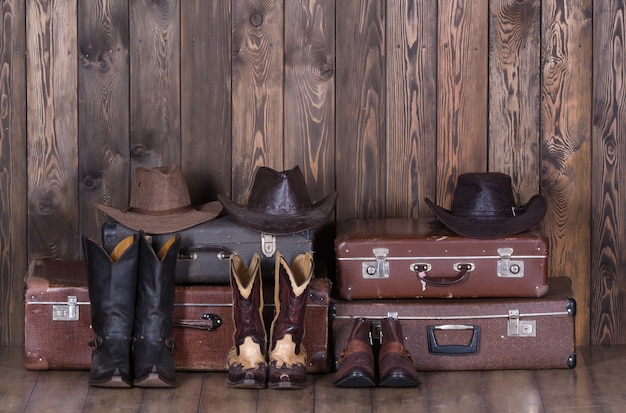 Chapéus de malas velhas e sapatos de cowboy