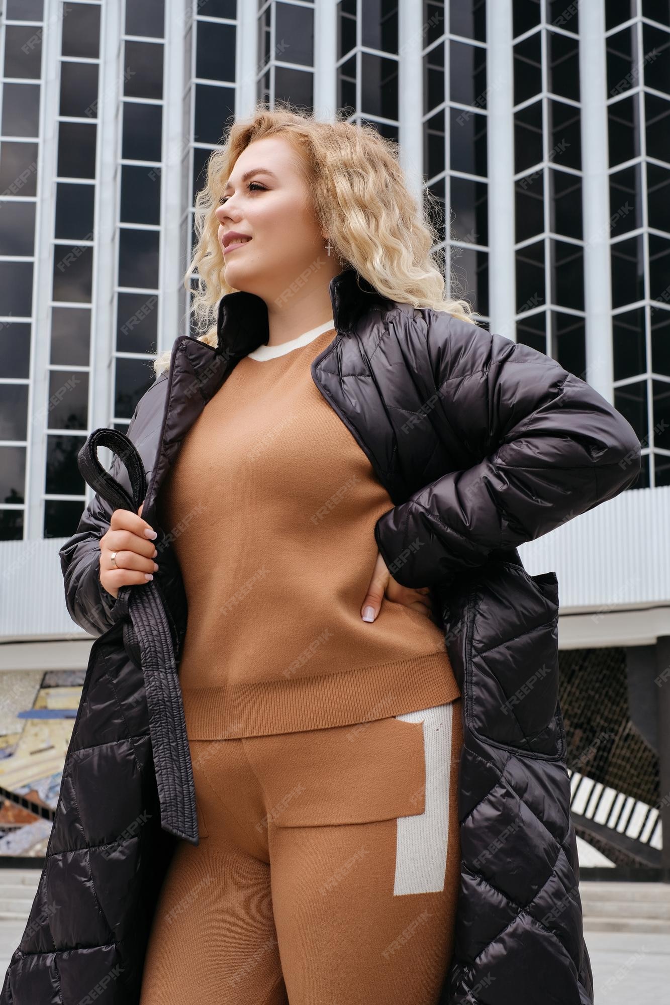 Chaqueta de abrigo acolchado negro de moda para mujer rubia modelo de pancarta publicitaria de urbano de gran tamaño de talla grande | Foto Premium