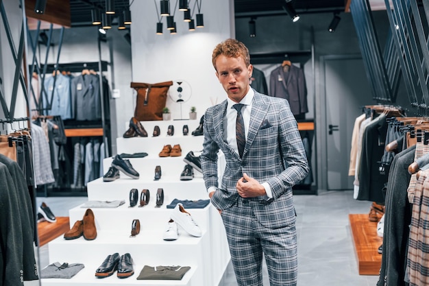 En chaqueta con corbata Chico joven en una tienda moderna con ropa nueva Ropa elegante y cara para hombres