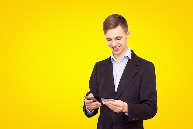 Chaqueta de hombre y camisa azul con teléfono y tarjeta de crédito, aislados sobre fondo amarillo