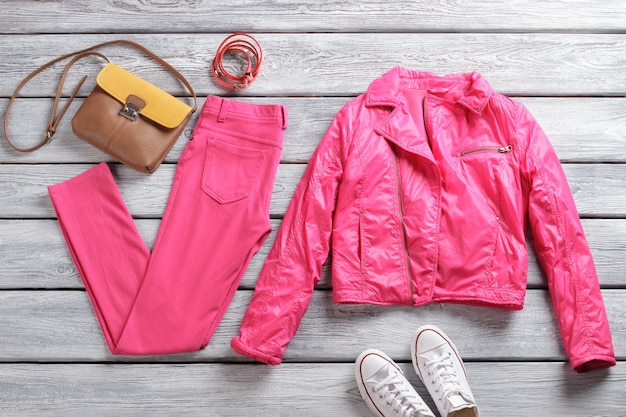 Chaqueta y pantalón rosa. Zapatos y pantalones de lona blanca. Prendas de abrigo brillantes y accesorios elegantes. Idea de atuendo casual para primavera.