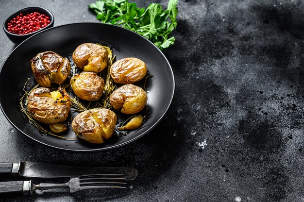 Chaqueta de papa al horno con ajo y romero en un plato