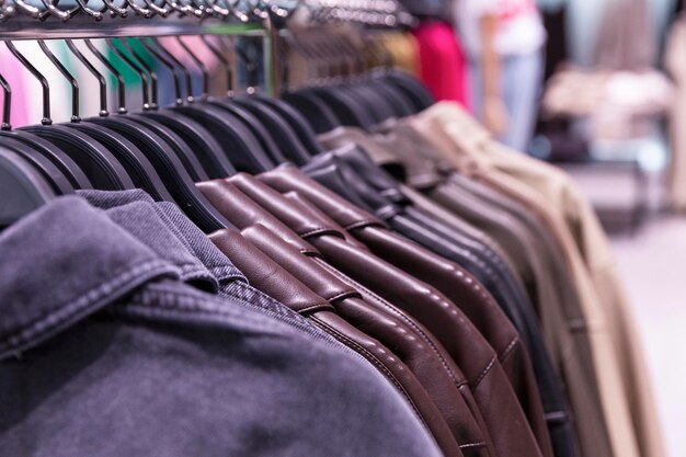 Chaquetas en perchas en la tienda. Estilo y moda. De cerca.