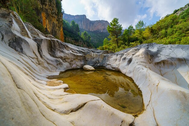 Charco de agua atrapado entre las rocas erosionadas del valle montañoso.